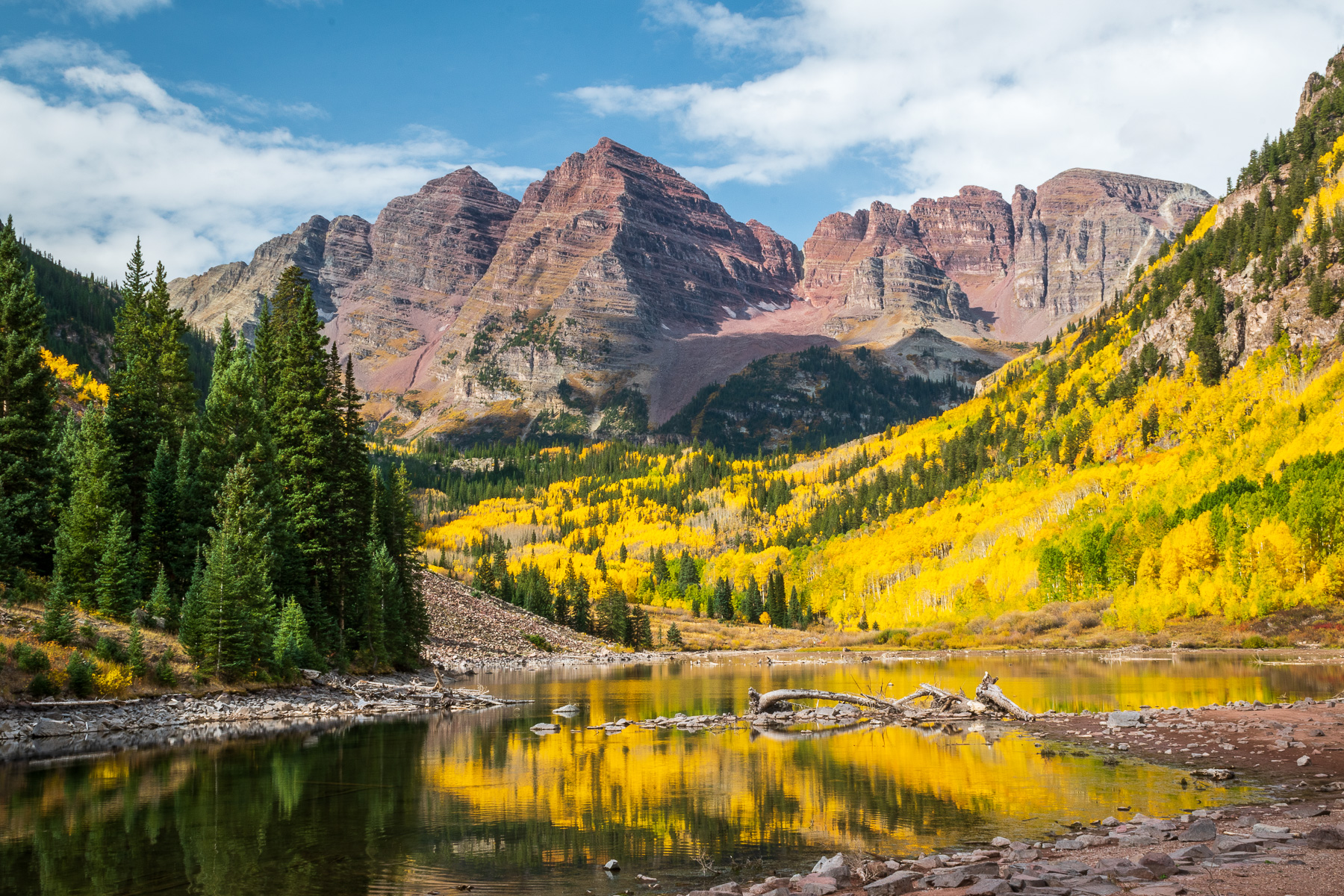 Maroon Bells and golden aspen trees on a fall day.